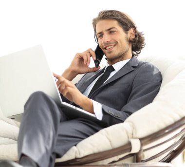 onun evinde sandalyede oturan smartphone cep telefonu ile konuşurken işadamı