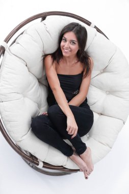 büyük yumuşak koltukta istirahat gülümseyen genç kadın