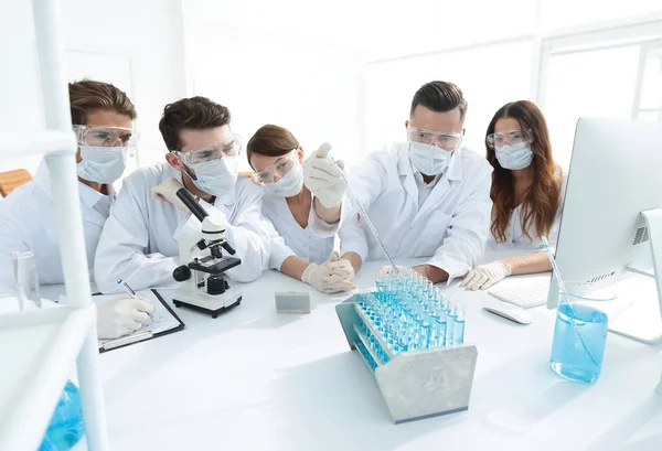 Médicos están trabajando con tubos de ensayo y microscopio en el laboratorio — Foto de Stock