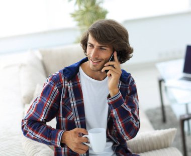 güzel bir fincan adamla bir dizüstü bilgisayar önünde oturur.