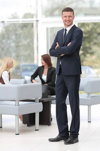 Succesvolle zakenman permanent in de lobby van zijn ambt. — Stockfoto