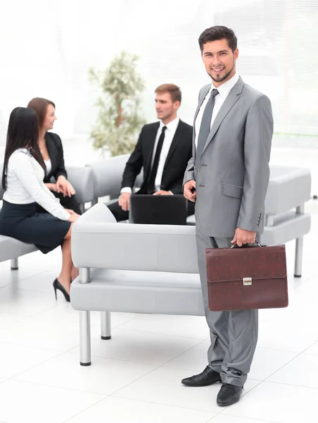 Uomo d'affari fiducioso con valigetta in piedi nella hall dell'ufficio . — Foto Stock