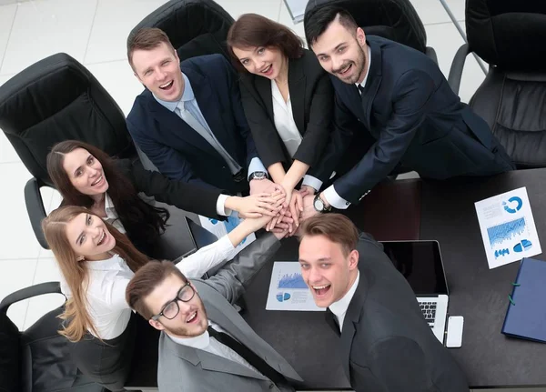 Equipo de negocios con las manos juntas en el escritorio —  Fotos de Stock