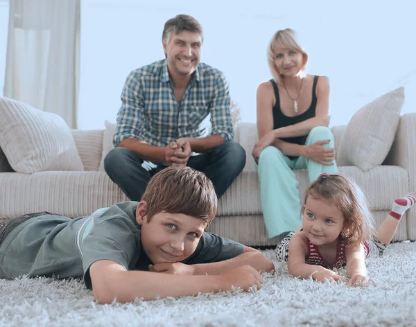 Retrato de família feliz sentados juntos na sala de estar — Fotografia de Stock