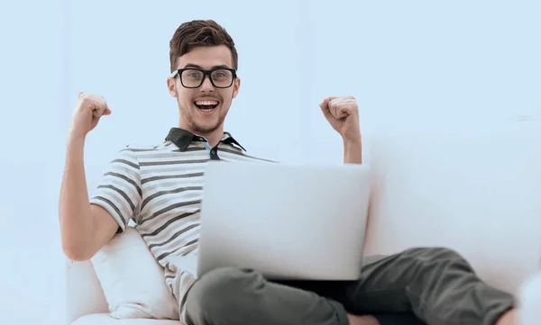 Happy man with laptop sitting on the couch — Stock Photo, Image