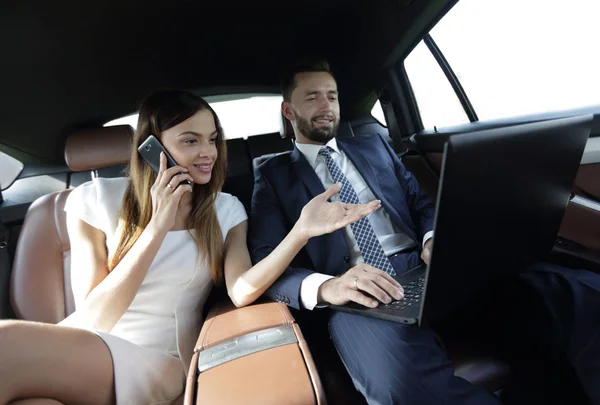 車の後部座席で携帯電話で話している実業家 — ストック写真