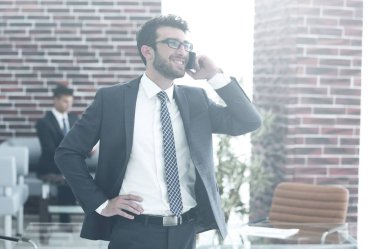 ofisinde smartphone cep telefonu ile konuşurken işadamı