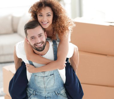 Yeni bir evde kucaklaşan mutlu aile çifti.