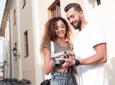 Fotoğraflara bakarak yürüyen genç arkadaşların portresi