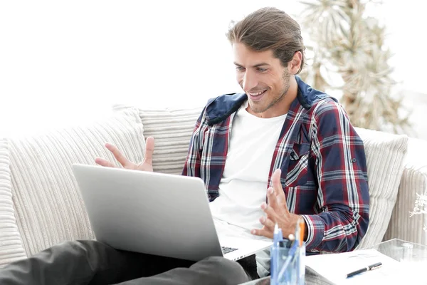 Szczęśliwy młody mężczyzna pracujący z laptopa z domu. — Zdjęcie stockowe
