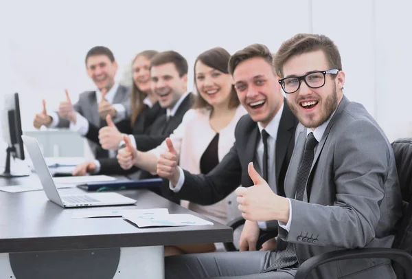 Επιχειρηματική ομάδα με τους αντίχειρες επάνω ενώ κάθεται στο γραφείο του — Φωτογραφία Αρχείου