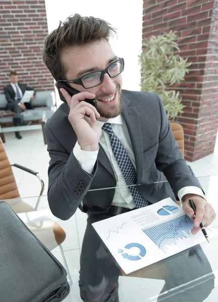 Business man talking on smartphone at his Desk — стоковое фото