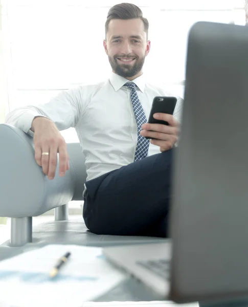 Бізнесмен тримає смартфон і дивиться на камеру — стокове фото