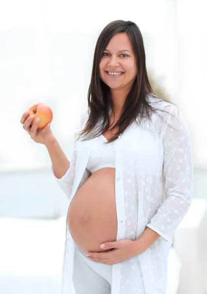 Donna incinta sorridente con una mela — Foto Stock