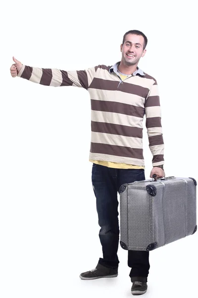 Young man sits on the big suitcase — Stock Photo, Image