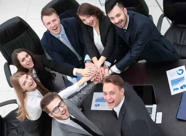 Equipe de negócios com as mãos apertadas juntas na mesa — Fotografia de Stock