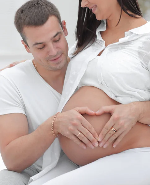 Крупный план .husband и беременная жена положить руки на животик . — стоковое фото