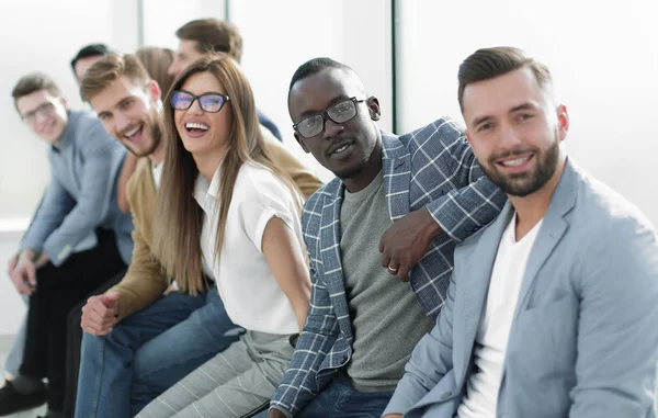 Young people sitting at the wall waiting for their turn at the interview — Stock Photo, Image