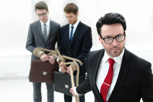 De cerca. hombre de negocios serio tira de socios de negocios atados con una cuerda — Foto de Stock
