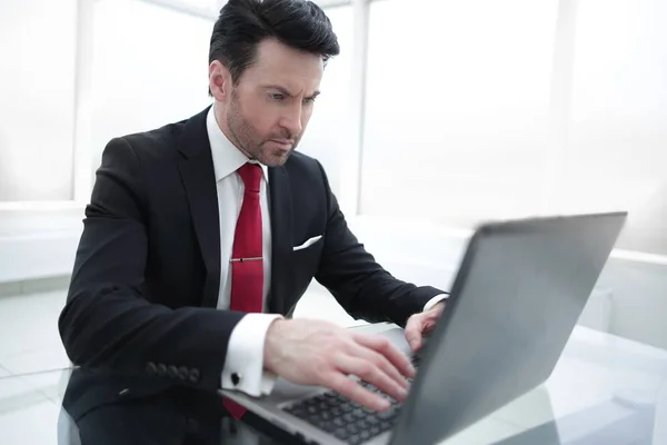 Επιχειρηματίας πληκτρολογώντας σε ένα φορητό υπολογιστή, κάθεται στο γραφείο του — Φωτογραφία Αρχείου