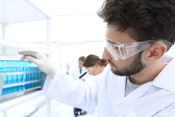 Vista lateral del científico enfocado sosteniendo el tubo de ensayo en laboratorio —  Fotos de Stock