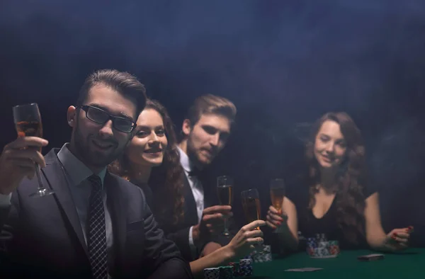 Jogadores de poker com um copo de vinho, sentado a uma mesa — Fotografia de Stock