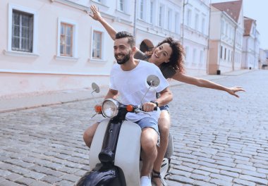 mutlu genç bir çift bir scooter üzerinde eğleniyor