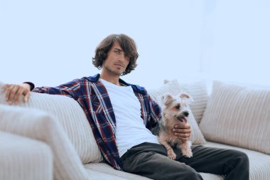 şık adam köpeğiyle kanepede oturan.