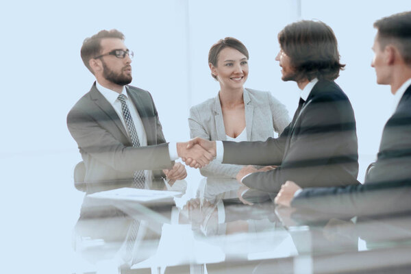 from behind the glass.handshake of business partners