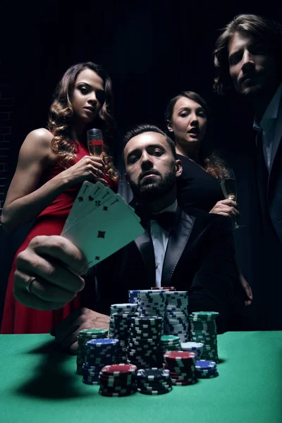 Концентровані чоловіки та жінки грають у покер у казино ліцензованих запасів