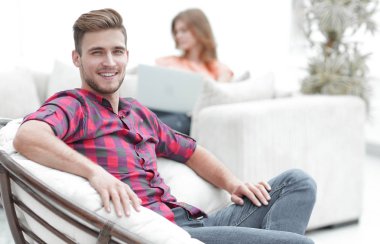 büyük sandalyede oturan genç adam