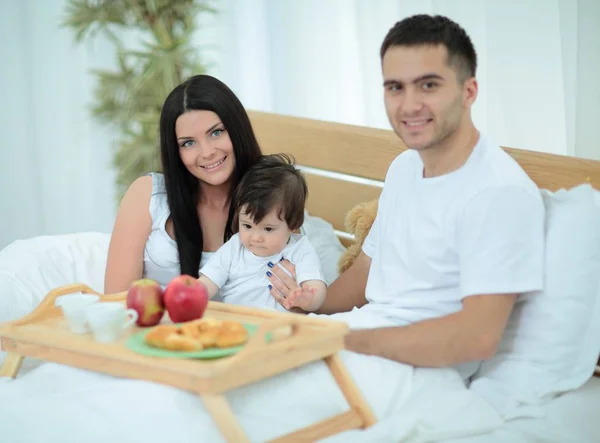 Família tomando café da manhã na cama em casa — Fotografia de Stock