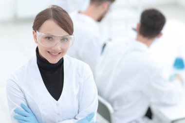 Laboratuvar arka planda bilim adamı portresi.