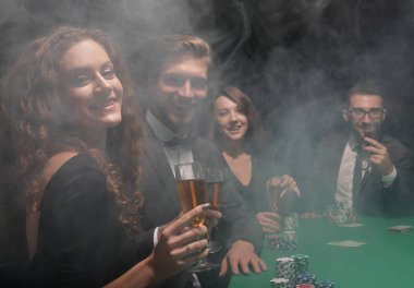 Casino oyun masasında oturan arkadaş grubu