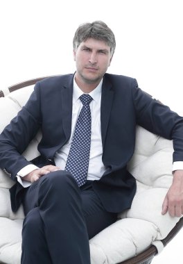 Başarılı bir iş adamı yumuşak bir rahat sandalyede oturur.