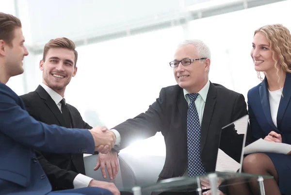 Partners ingår avtal och skakar hand i närvaro av lagmedlemmar — Stockfoto