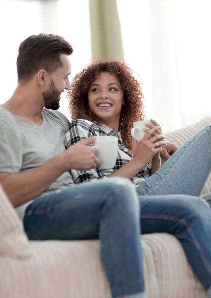 Sevgi dolu çift kanepe oturma odasında oturup çay içme — Stok fotoğraf
