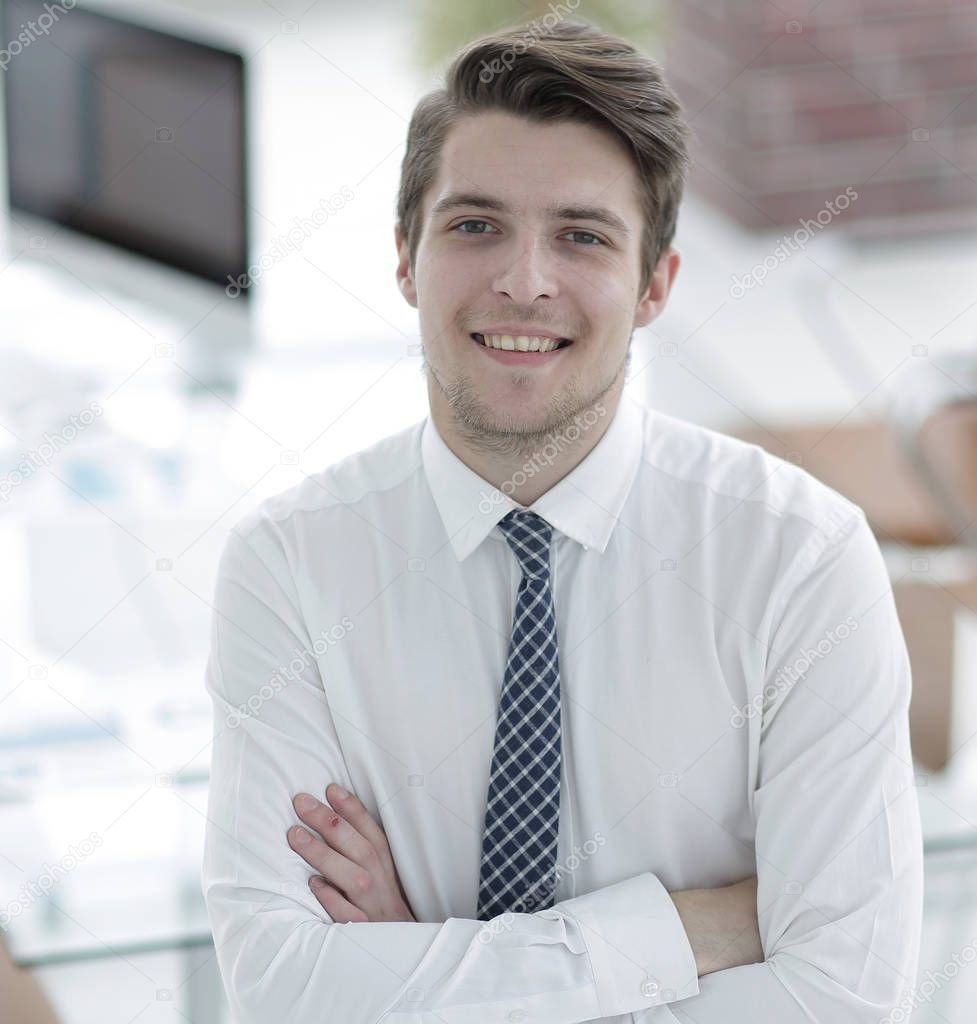confident young businessman on background of office