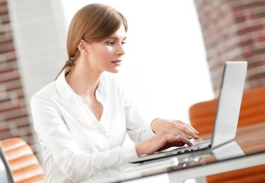 ofiste dizüstü bilgisayar üzerinde çalışan kadın Yardımcısı.