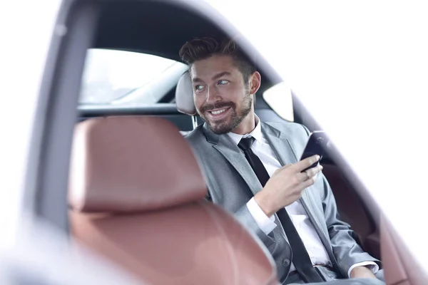 Homme d'affaires souriant assis sur le siège arrière dans sa voiture — Photo