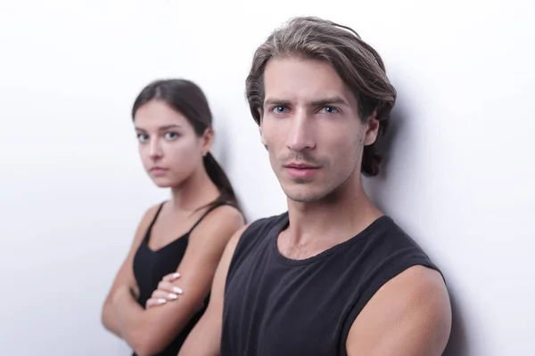 Serious young couple standing near the wall — Stock Photo, Image