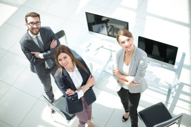 üstten görünüm. üç çalışanın ofiste ayakta