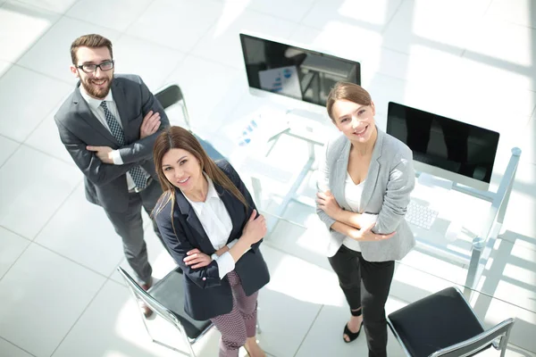 üstten görünüm. üç çalışanın ofiste ayakta