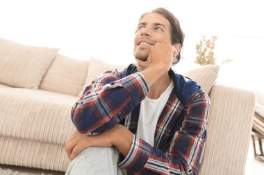 yeni bir daire içinde halı üzerinde mutlu bir adam Close-Up.