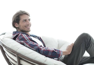 yakın çekim. gülümseyen adam büyük bir rahat sandalyede dinleniyor