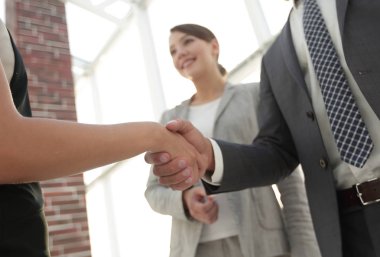 İş adamları geniş pencereli odaya karşı el sıkışıyor