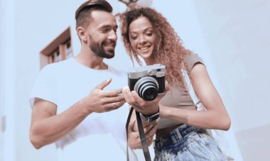 Fotoğraflara bakarak yürüyen genç arkadaşların portresi