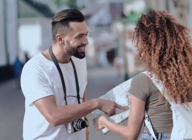 Genç çift mutlu görünürken bir rehbere bakıyor.