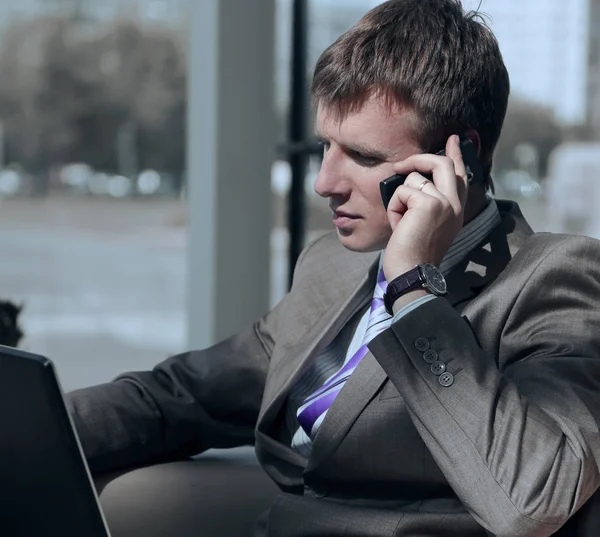 Atraente europeu cara falando no telefone enquanto usando laptop . — Fotografia de Stock