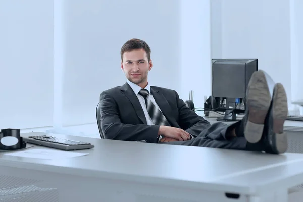 Selbstbewusster Geschäftsmann sitzt am Schreibtisch in einem privaten Büro — Stockfoto